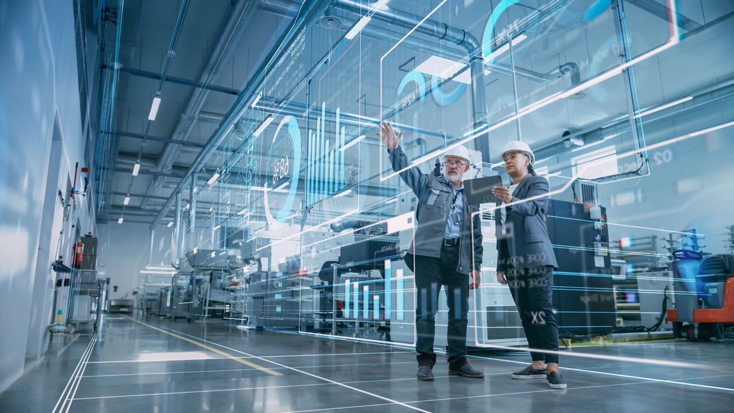 Operarios industriales con casco analizando un panel de datos holográfico en una planta de producción